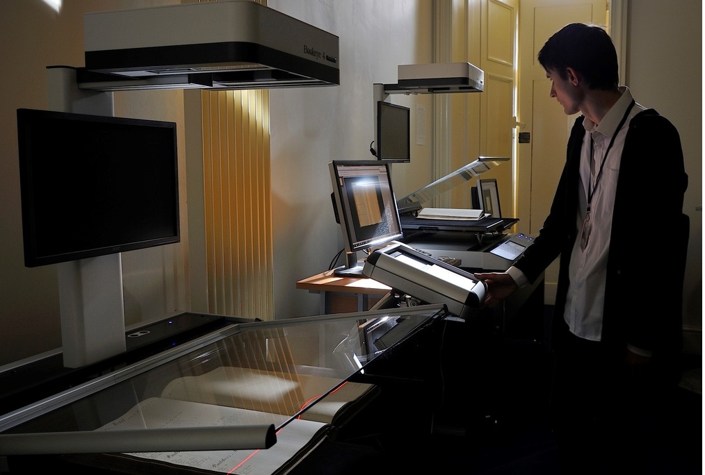 Staff member scanning documents on a hi-tech scanning machine
